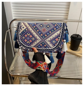 Detail of bohemian woven crossbody bag featuring colorful patterns and tassel accents