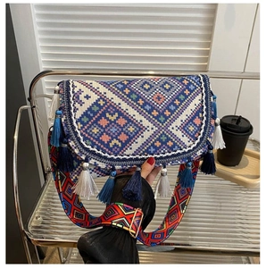 Close-up of bohemian woven crossbody bag with colorful tassels and ethnic embroidery
