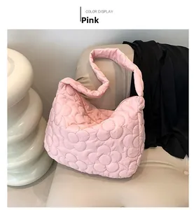 Detail of pink quilted tote bag with petal pattern stitching on a minimalist background
