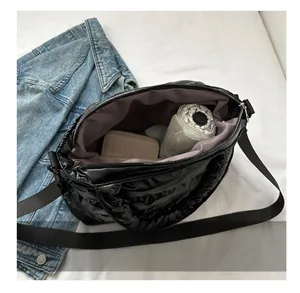 Top view of large black quilted puffer bag showing spacious pink interior with essentials