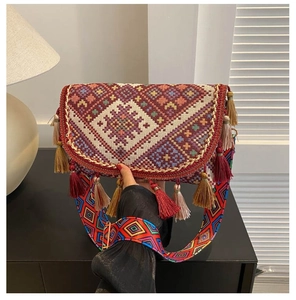 Close-up of bohemian woven crossbody bag featuring colorful tassels and ethnic patterns