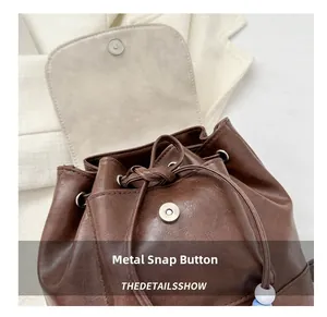 Detail of vintage brown PU leather backpack with magnetic snap and drawstring closure