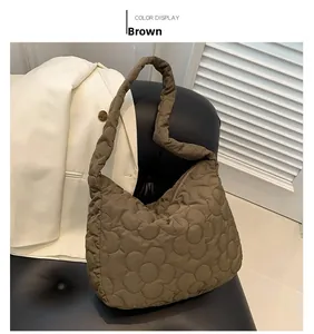 Close-up detail of quilted flower pattern on brown puffy nylon tote shoulder bag