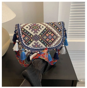 Detail of bohemian style crossbody bag with colorful tassels and jacquard shoulder strap