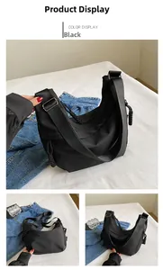 Détail du sac croissant en nylon noir avec tirette à nœud tressé et bandoulière large