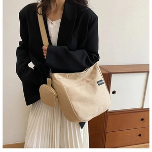 Detail of beige canvas tote bag with fashion label and detachable round coin purse