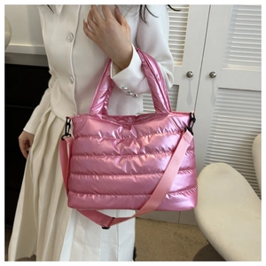 Detail view of pink glossy puffer tote bag with quilted padding and wide fabric strap