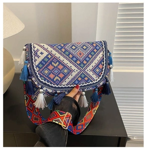 Detail of bohemian crossbody bag with colorful geometric patterns and fringe tassels