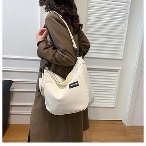 Detail of white large-capacity canvas tote bag with fashion label and small coin pouch