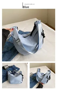Vue détaillée du sac bandoulière croissant bleu clair avec large sangle en tissu réglable