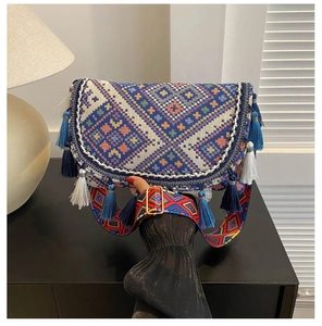 Detail view of ethnic embroidery crossbody bag with colorful tassels and woven strap