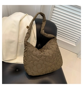 Close-up of khaki brown tote bag featuring quilted 3D floral pattern and nylon texture