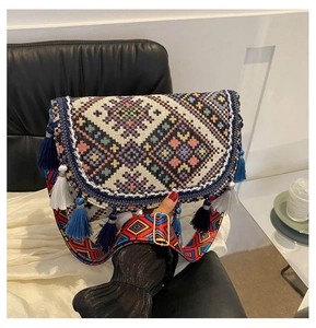 Detail of bohemian crossbody bag with colorful geometric embroidery and blue fringe