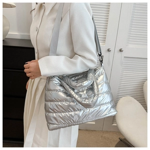 Detail of silver quilted tote bag with metallic texture and adjustable shoulder strap