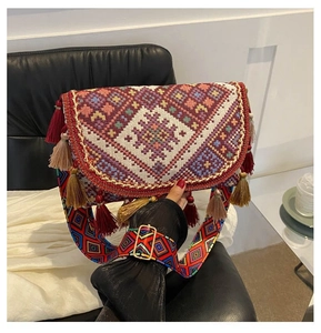 Detail of bohemian crossbody bag showing ethnic embroidery and colorful tassel fringe