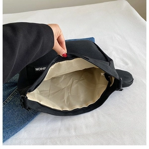 Macro view of spacious black canvas tote interior with cream lining and fashion label