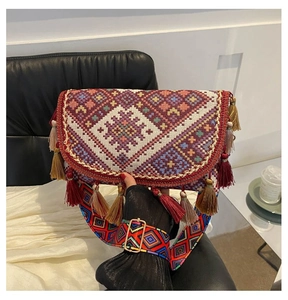 Detail of bohemian shoulder bag with ethnic geometric patterns and colorful long tassels