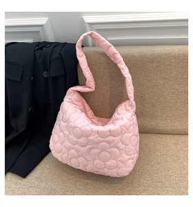 Detail of pink quilted tote bag with floral pattern and soft padded texture
