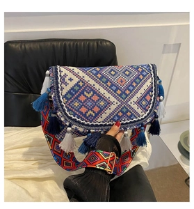 Detail of bohemian woven crossbody bag featuring colorful geometric patterns and fringe