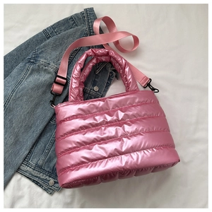 Detail of metallic pink quilted shoulder bag with wide strap and shiny finish