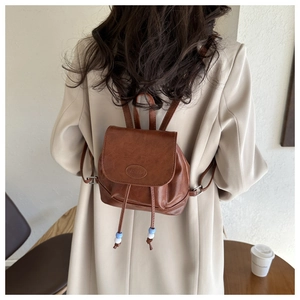 Detail of vintage dark brown faux leather mini backpack with Fashion embossed logo and drawstring