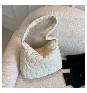 Macro shot of cream white tote bag with floral quilted pattern on cozy soft fabric
