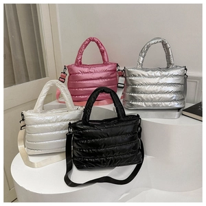 Quilted tote bags shown in pink, silver, white and black colors on a white display stand