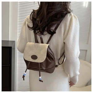 Detail showing vintage mini drawstring backpack in dark brown and beige on model
