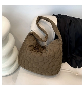 Detailed view of coffee brown quilted tote bag with unique 3D flower pattern stitching
