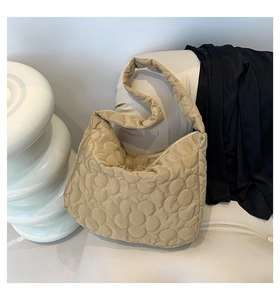 Macro view of flower quilted pattern and soft puffy texture on the khaki tote bag