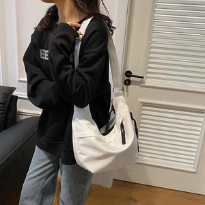 Détail du sac bandoulière blanc en nylon avec sangle ajustable et forme demi-lune