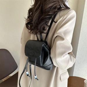Minimalist black leather mini backpack with drawstring and stylish bead tassels