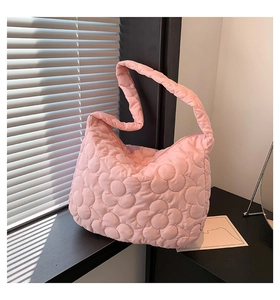 Close-up of pink quilted tote bag showing detailed 3D floral stitching and soft texture