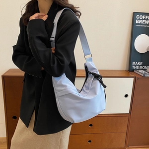 Détail du sac hobo croissant bleu clair avec large bandoulière et accents de cordon