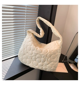 Close-up of quilted floral pattern and soft padded texture on beige tote bag