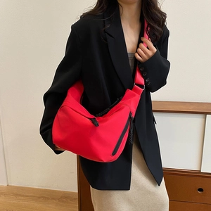 Sac bandoulière rouge en nylon en forme de demi-lune avec large bandoulière et tirette noire
