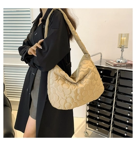 Detail of floral quilted tote bag showing padded texture and khaki shoulder strap