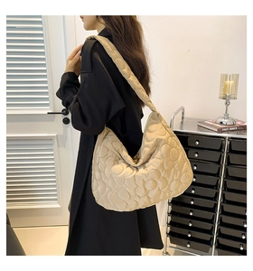 Detail of beige quilted cloud tote bag featuring floral textures and padded nylon fabric