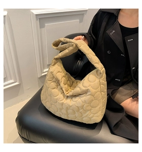 Detail of khaki quilted tote bag with floral stitching and soft padded shoulder strap