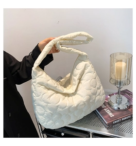 Detail showing creamy white quilted floral pattern on lightweight nylon shoulder tote bag