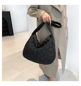 Detail of black quilted tote bag showing the 3D camellia floral texture and nylon fabric