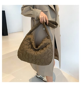 Detail view of brown floral quilted tote bag with wide strap for a soft puffy texture