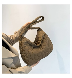 Detailed view of the large flower quilted pattern on a brown nylon puffer tote bag
