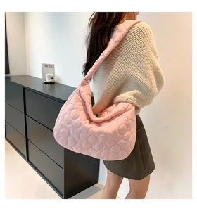 Close-up of pink quilted puffer tote bag with large floral texture and soft padded strap