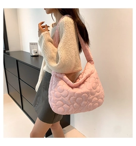Detail of pink quilted hobo bag with 3D floral pattern and padded shoulder strap
