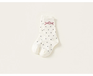 Close-up of cream girls' socks with vertical stripes, black dots, and pink silk bows