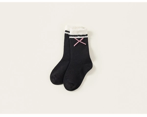 Detail of black girl socks featuring plush white faux fur cuffs and pink bow accents