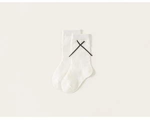 Detail of white cotton mid-calf socks with wave knit texture and black cross ribbons