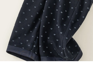 Détail du tricot bleu foncé avec motifs petits cœurs gris pour pantalon décontracté
