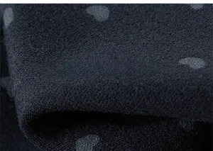 Vue détaillée du tissu en maille avec motif de cœur montrant la texture douce du coton
